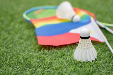 Beyaz krema servisi, badminton spor ekipmanları, Filipinler bayrağı ve gökkuşağı bayrağının önündeki yeşil çimlere yerleştirilmiş yerler, tüm cinsiyetler ve lgbtq + insanlar için badminton sporu kavramı.