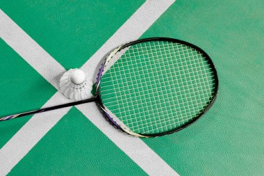 Badminton spor ekipmanları, raketler ve mekiklerin horozları, kapalı sahada badminton zemininde, yumuşak odaklanma.