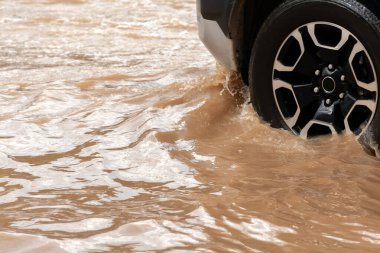 Şiddetli yağışlı bir mevsim nedeniyle çamurlu yağmurlar bölgeyi birbirine bağlayan ana yolları sular altında bıraktı, arabaların geçmesini zorlaştırdı ve motor arızalarına yol açtı, hareket halinde, araba sigortası konsepti, hareket halinde.