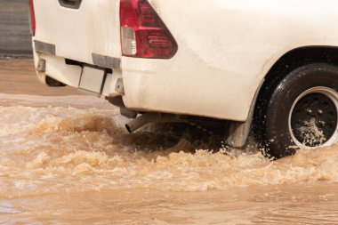 Şiddetli yağışlı bir mevsim nedeniyle çamurlu yağmurlar bölgeyi birbirine bağlayan ana yolları sular altında bıraktı, arabaların geçmesini zorlaştırdı ve motor arızalarına yol açtı, hareket halinde, araba sigortası konsepti, hareket halinde.