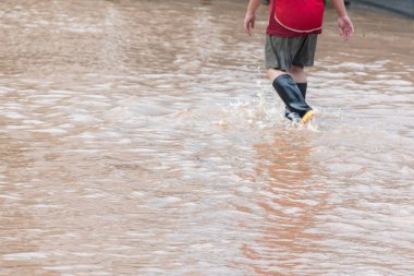 Asyalı adam lastik çizme ya da Wellingtons giyer seller sırasında sokaklarda yürürken, odaklanır, sağlık konsepti oluşturur..