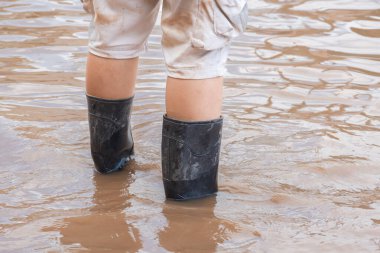 Asyalı adam lastik çizme ya da Wellingtons giyer seller sırasında sokaklarda yürürken, odaklanır, sağlık konsepti oluşturur..