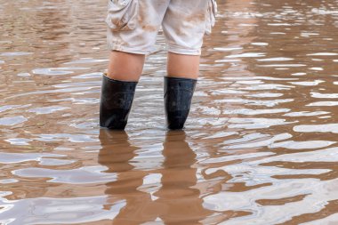 Asyalı adam lastik çizme ya da Wellingtons giyer seller sırasında sokaklarda yürürken, odaklanır, sağlık konsepti oluşturur..