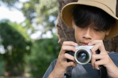 Kameralı şapkalı genç bir fotoğrafçının yakın plan portresi objektiften konuya odaklanıyor..
