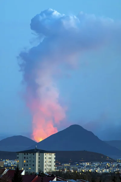 夕暮れのレイキャビクから見たファジャラール火山の噴火 — ストック写真