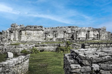 Tulum kalıntıları Meksika 'nın kıyı şeridindeki antik Maya yapılarıdır, yıpranmış taş duvarlar ve sütunlar içerir, zengin bir kültürel tarihi yansıtır, yemyeşil ve kıyı manzarası arasında yer alır.