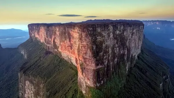 Monte Roraima Ulusal Parkı, Venezuela 'dan, rengarenk gökyüzünün altında alacakaranlıkta Roraima Dağı manzarası. Dağ, Venezuela, Brezilya ve Guyana olmak üzere üç ülkenin üzerinde yer almaktadır..