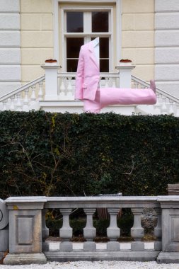 Salzburg, Avusturya - 30 Kasım 2019: Pembe takım elbiseli ve bacağı Salzburg 'daki Mirabell Palace ve Gardens' a giden yarım gövde heykeli.