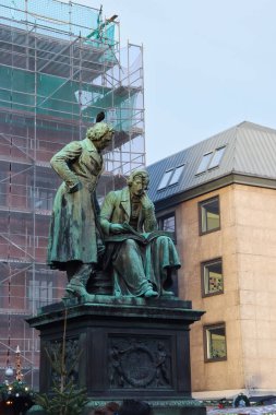 Hanau, Almanya - 15 Aralık 2019: Hanau, Almanya 'da kafasında siyah kuş olan Grimm kardeşler heykeli.