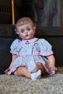 Taş ocağın önünde yerde oturan antika bebek..