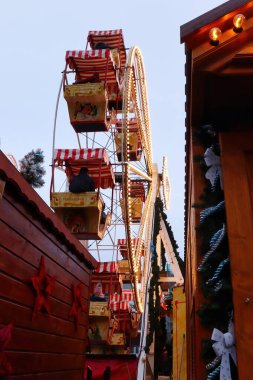 Hanau, Almanya - 15 Aralık 2019: Bulutlu bir günde Almanya 'nın Hanau kentindeki bir Noel pazarında renkli bir antika dönme dolabın arkası.