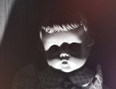 Gözlerinde gölgeler olan antika bir bebeğin ürkütücü görüntüsü.