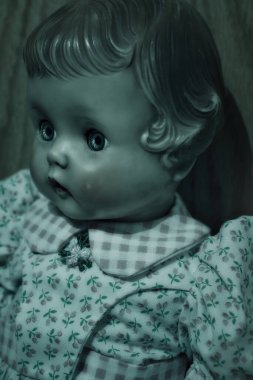 Çiçekli elbisesi olan antika bir bebeğin yeşil ışığı.