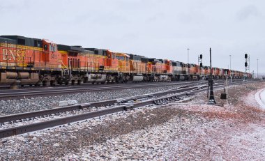 Gillette, Wyoming - 23 Ocak 2021: Soğuk bulutlu bir kış gününde Gillette, Wyoming 'in dışındaki bir raylarda uzun tren motorları depolandı..