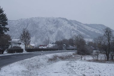 Bad Munster am Stein-Ebernburg, Germany - Febryary 8, 2021: Mountains behind small village in Germany on a dark, cold, grey, snowy winter day.