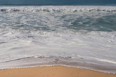 Portekiz, Lizbon yakınlarındaki bir plajda kış günü Atlantik Okyanusu 'nda köpük var..