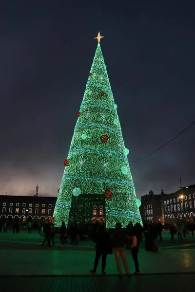 stock image Lisbon, Portugal - December 23, 2019: People around a Christmas tree in Praca do Commercio Plaza on a winter night in Lisbon, Portugal.