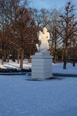 Karlsruhe, Almanya - 12 Şubat 2021: Almanya 'da bir kış öğleden sonra Karlsruhe Sarayı' nda beyaz heykelin üzerinde güneş parlıyor.