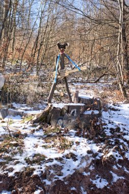 Winnweiler, Almanya - 14 Şubat 2021: Almanya 'nın Palatinate Ormanı' nda güneşli bir kış gününde, kar altında bir ağaç kütüğünde gitar tutan kişinin küçük ahşap oyması.