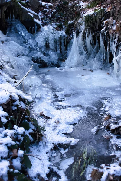 小さな溝の氷柱と氷は ドイツのウィナーワイラー近くの冬の日にパラチネートの森の散歩道の横にあります — ストック写真