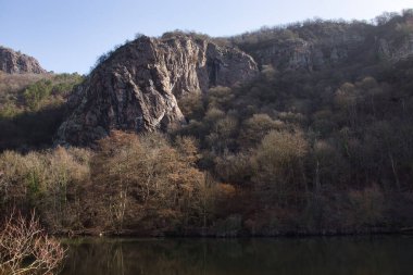 Güneş, Rotenfels 'te bir kaya oluşumunda parıldıyor. Almanya' da bir kış günü, Nahe nehrinin üzerinde ağaçlar olan bir tepede..