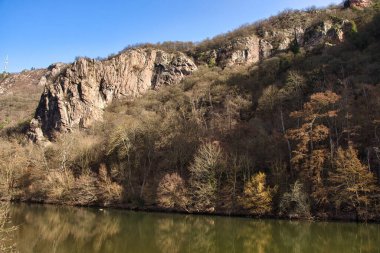 Almanya 'nın Bad Munster kentindeki Nahe Nehri üzerinde güneşli bir kış gününde kaya oluşumu.