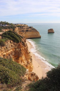 Carvoeiro, Portekiz - 25 Aralık 2019: Algarve, Portekiz 'de güneşli bir kış gününde kireçtaşı kayalıkları olan Marinha Sahili.