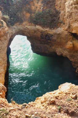 Portekiz 'in Algarve şehrinde bir kış günü Atlantik Okyanusu' nda kireçtaşı kayalıklarda su ile delik.