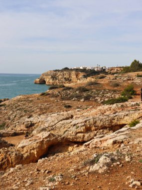 Carvoeiro, Portekiz - 25 Aralık 2019: Güneşli bir kış günü Portekiz 'in Algarve kentinde kayalıklar ve Atlantik Okyanusu' nun yanında binalar.