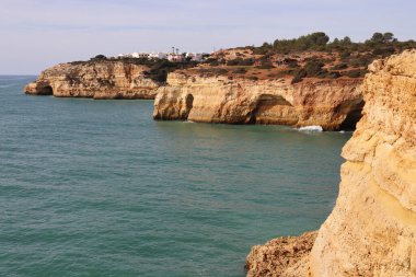 Güney Portekiz 'deki Yedi Asılı Vadi Patikası boyunca güneşli bir kış gününde Atlantik Okyanusu' nun yanında küçük bir kasabası olan kireçtaşı kayalıkları..