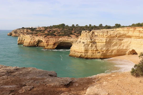 stock image Small sandy beach and limestone cliffs around water in the Atlantic Ocean on a sunny winter day in southern Portugal on the Seven Hanging Valleys Trail.