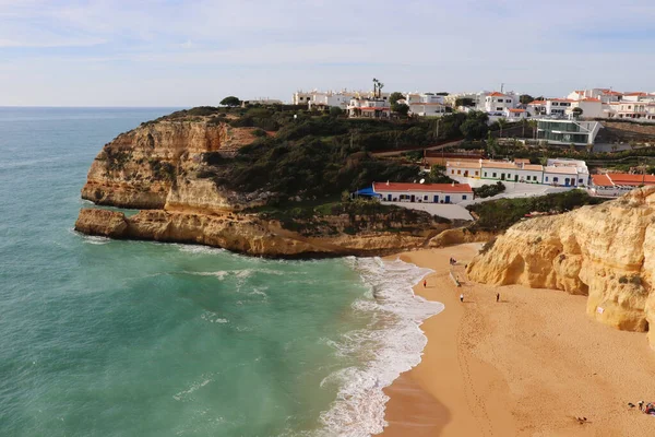 Algarve, Porgugal 'da güneşli bir kış gününde Atlantik Okyanusu' nun yanındaki kumlu bir plajda, uçurumun kenarındaki....