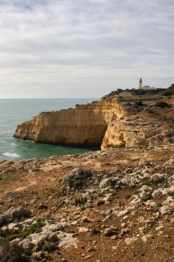 Carvoeiro, Portekiz - 25 Aralık 2019: Atlantik Okyanusu 'nun yukarısındaki Farol De Alfanzina Deniz Feneri' ne giden Yedi Asılı Vadi Yolu 'ndaki kireçtaşı uçurumlarındaki kayalar.