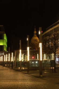 Kaiserslautern, Almanya - 16 Mart 2021: Kaiserslautern şehir merkezinde bir meydanda ışıklar sıralanır ve Volksbank 'ta bir kış gecesinde arka planda kule bulunur..