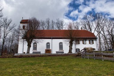 Winnweiler, Almanya - 17 Mart 2021: Kreuzkapelle Kilisesi 'nin yamacında, Winnweiler, Almanya' da bulutlu bir kış gününde çitleri ve yeşil çimenleri olan pencereler.