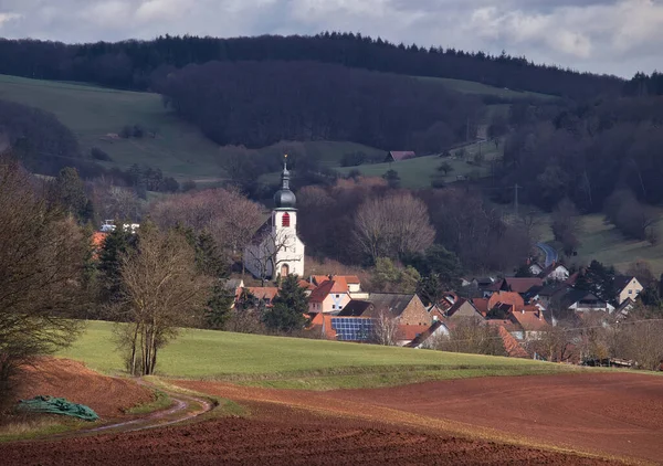 德国温韦勒 2021年3月17日 在德国温韦勒 在多云的冬日 阳光照射在被山丘和房屋环绕的新教教堂上 — 图库照片