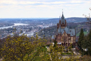 Konigswinter, Almanya - 16 Nisan 2021: Almanya 'da bulutlu bir bahar gününde, Konigswinter' a bakan bir tepenin üzerindeki Drachenburg Şatosu.