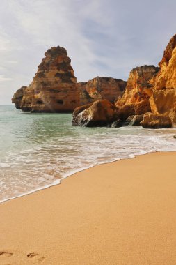 Sıcak bir kış gününde, Portekiz 'in güneyindeki bir sahilde güzel kum, su ve kayalar..