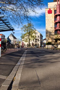 Bad Kreuznach, Almanya - 25 Nisan 2021: Bad Kreuznach, Almanya 'da bir bahar akşamı beyaz bir binanın önündeki bir ağaca çıkan cadde.