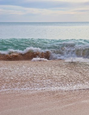 Güney Portekiz 'de bir kış günü kumlu bir sahilde dalgalar.
