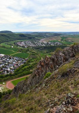 Bad Munster, Almanya - 9 Mayıs 2021: Yeşil tarlalarla çevrili Alman kasabalarına tepeden bakan Rotenfels uçurumunun kenarları.