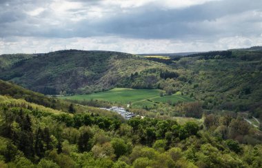 Bad Munster, Almanya - 12 Mayıs 2021: Rhineland Palatinate, Almanya 'da bulutlu bir bahar gününde yeşil ağaçlı ve otlu bir vadide güneş parlıyor.