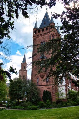 Weinheim, Almanya - 19 Mayıs 2021: Weinheim, Almanya 'da bir bahar günü parktaki beyaz bir binaya bağlı kule.