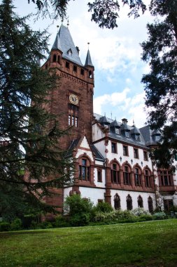 Weinheim, Almanya - 19 Mayıs 2021: Weinheim, Almanya 'da kahverengi kulesi olan beyaz bina.