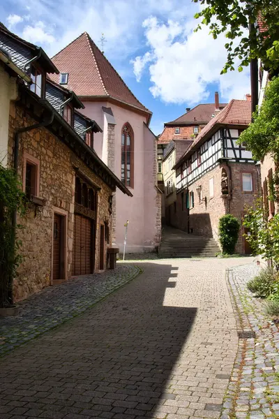 Weinheim, Almanya - 19 Mayıs 2021: Weinheim, Almanya 'da tarihi binaları olan bir kaldırım taşı caddesinde güneş ve gölgeler.