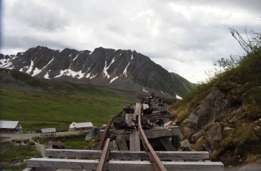 Palmer, Alaska - 14 Temmuz 2023 Alaska 'da bulutlu bir yaz gününde terk edilmiş Bağımsızlık Madeni' nin arkasındaki dağlar.