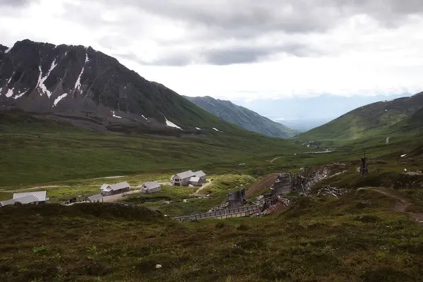 stock image Palmer, Alaska - July 14, 2023: Light shining on buildings in a valley at the abandoned Independence Mine in Alaska.