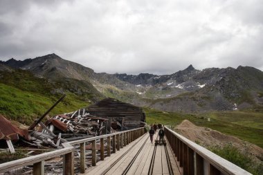 Palmer, Alaska - 14 Temmuz 2023: Bulutlu bir yaz gününde Alaska 'daki Independence Maden Eyalet Parkı' ndaki rayların arkasında güneş parlıyor.