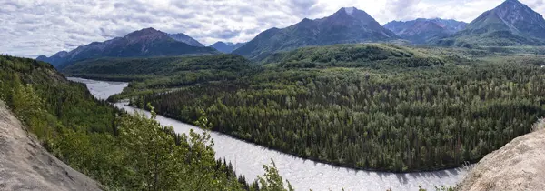 stock image Matanuska River with mountains in the distance on a  cloudy summer day in the Matanuska-Susitna Valley in Alaska.