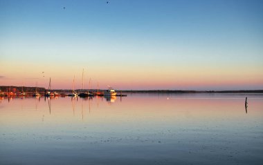 Rerik, Almanya - 29 Mayıs 2021: Botların üzerindeki renkli gökyüzü ve Kuzey Almanya 'daki Baltık Denizi sularındaki yansımaları.